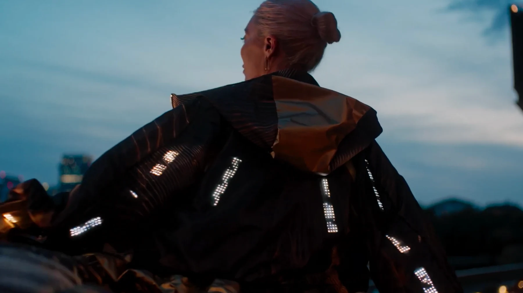 Francesca wearing the illuminated CuteCircuit coat for HONOR against the evening sky