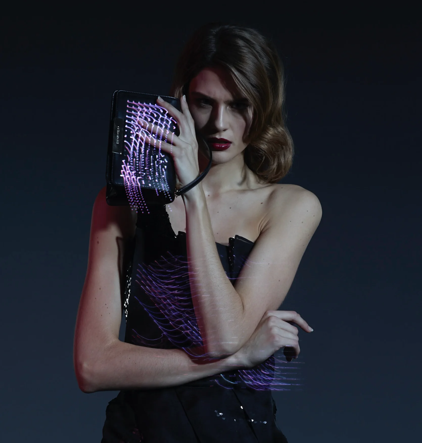 Model holding CuteCircuit’s illuminated leather Mirror Handbag while wearing the dress created for Nieves Álvarez