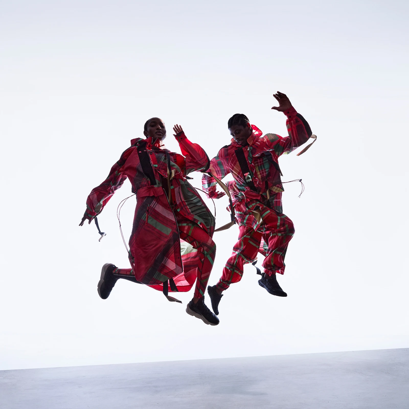 Two models jumping in the red patterned Kenya Olympic kit by CuteCircuit