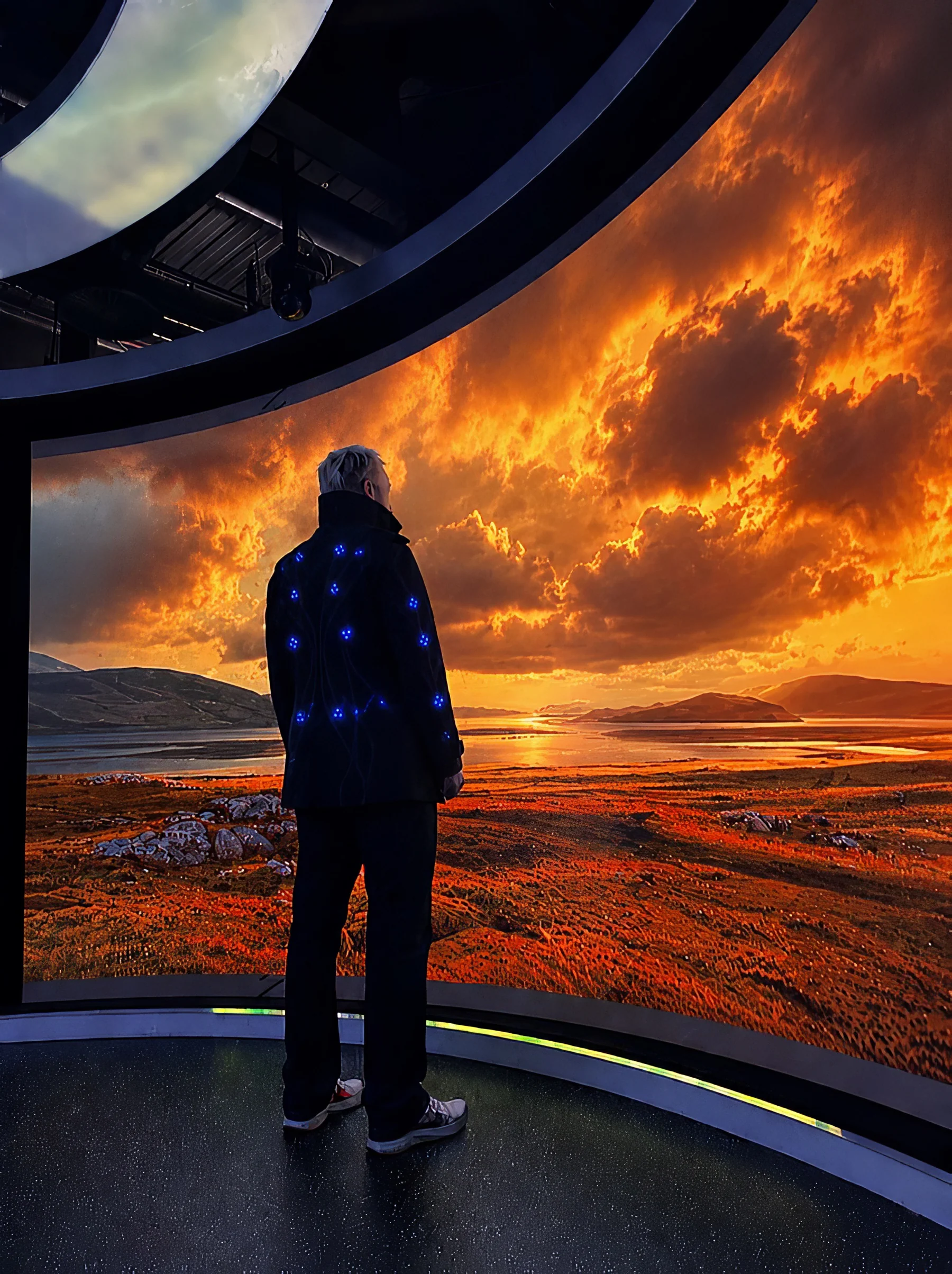 A visitor wearing illuminated technology inside The Storm’s immersive landscape