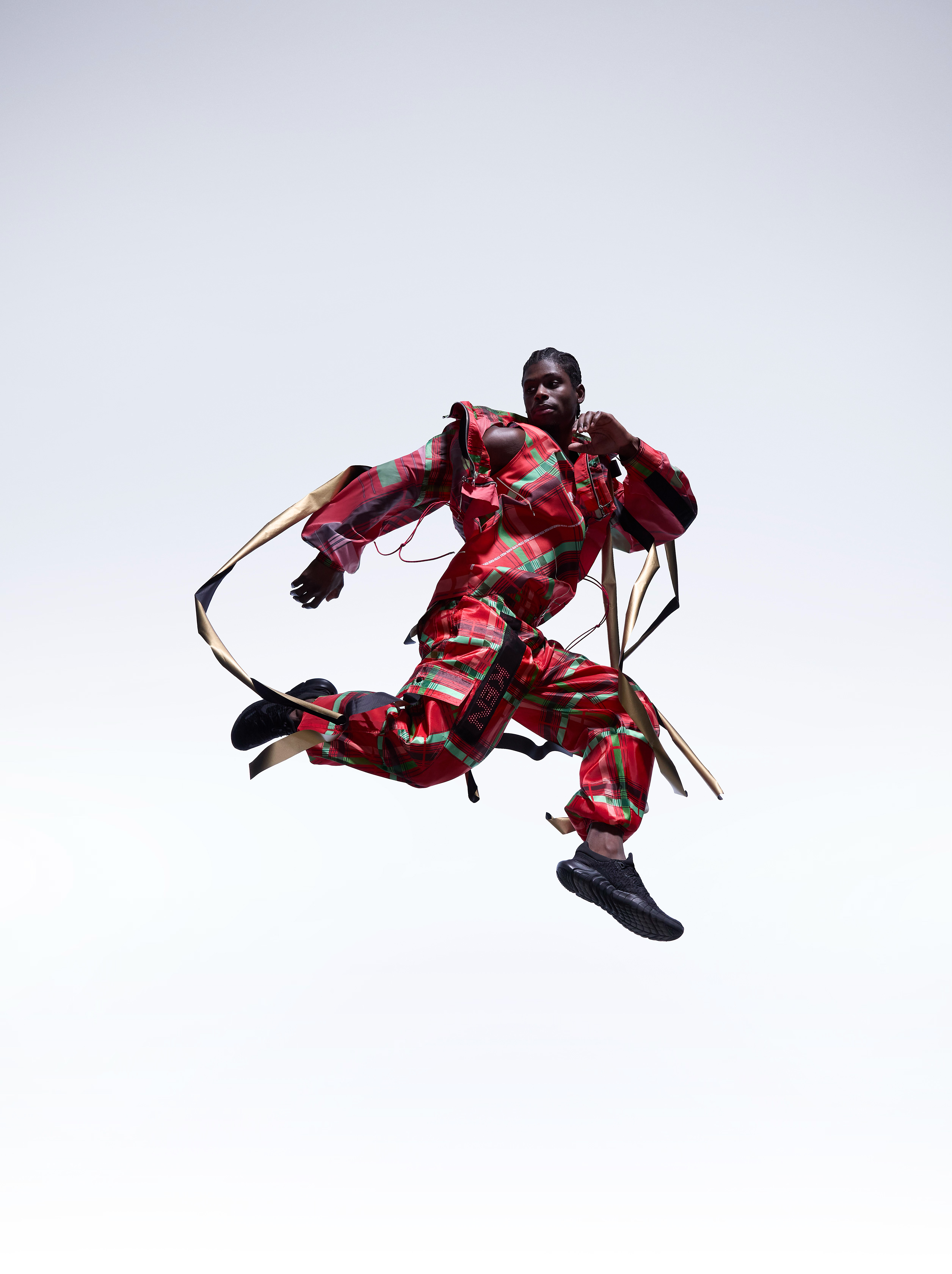 A model leaping mid-air in the red patterned garment from CuteCircuit’s Kenya project